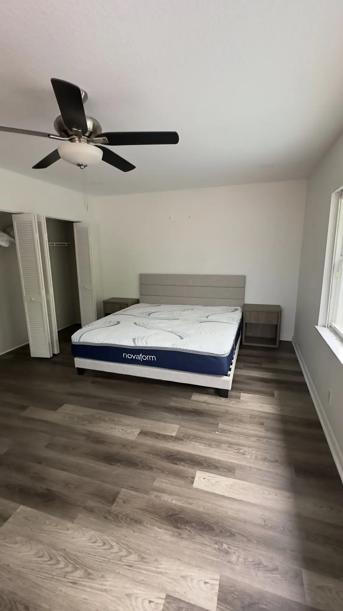Bedroom with a ceiling fan installed and new plank flooring