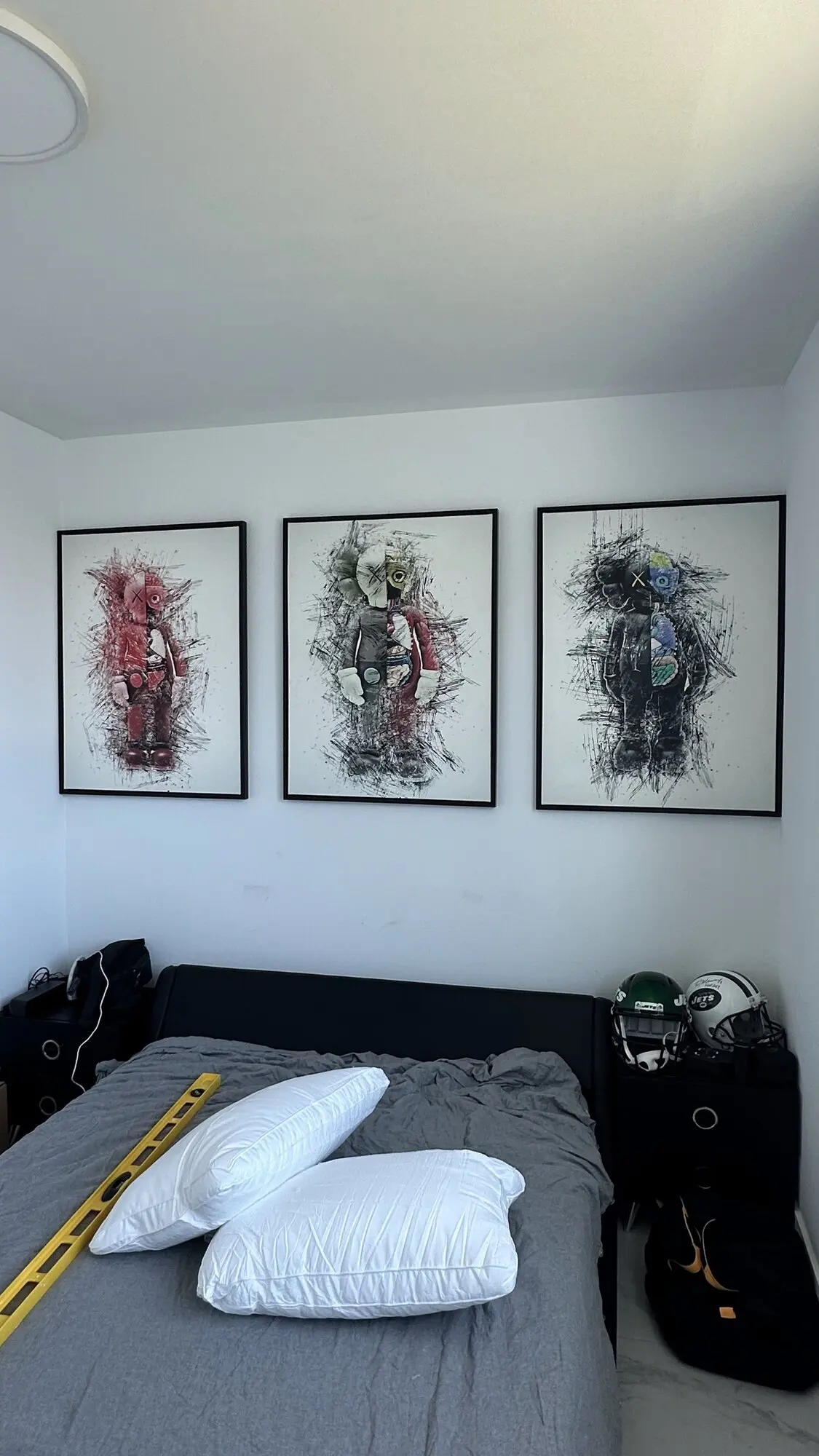 Three framed prints hung in a row on a bedroom wall
