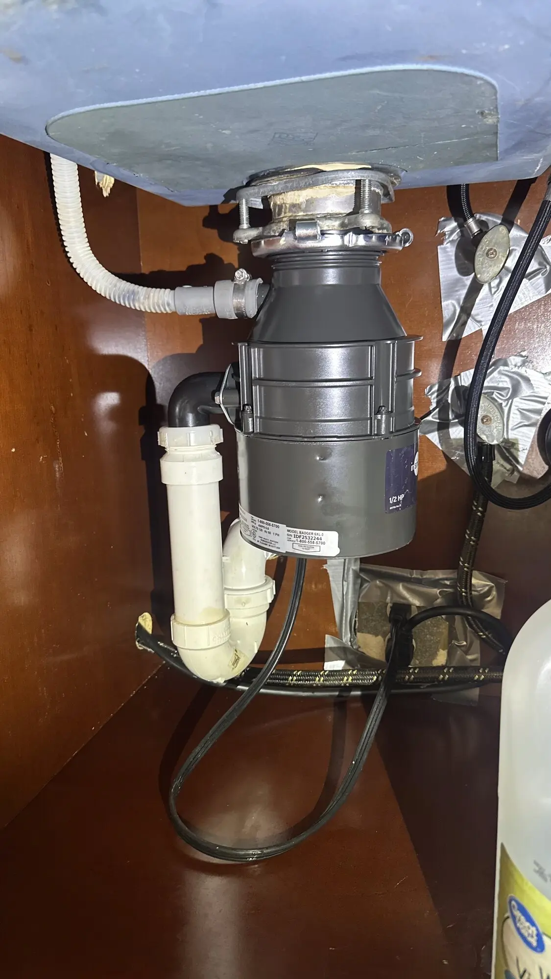 Garbage disposal replacement under a kitchen sink cabinet