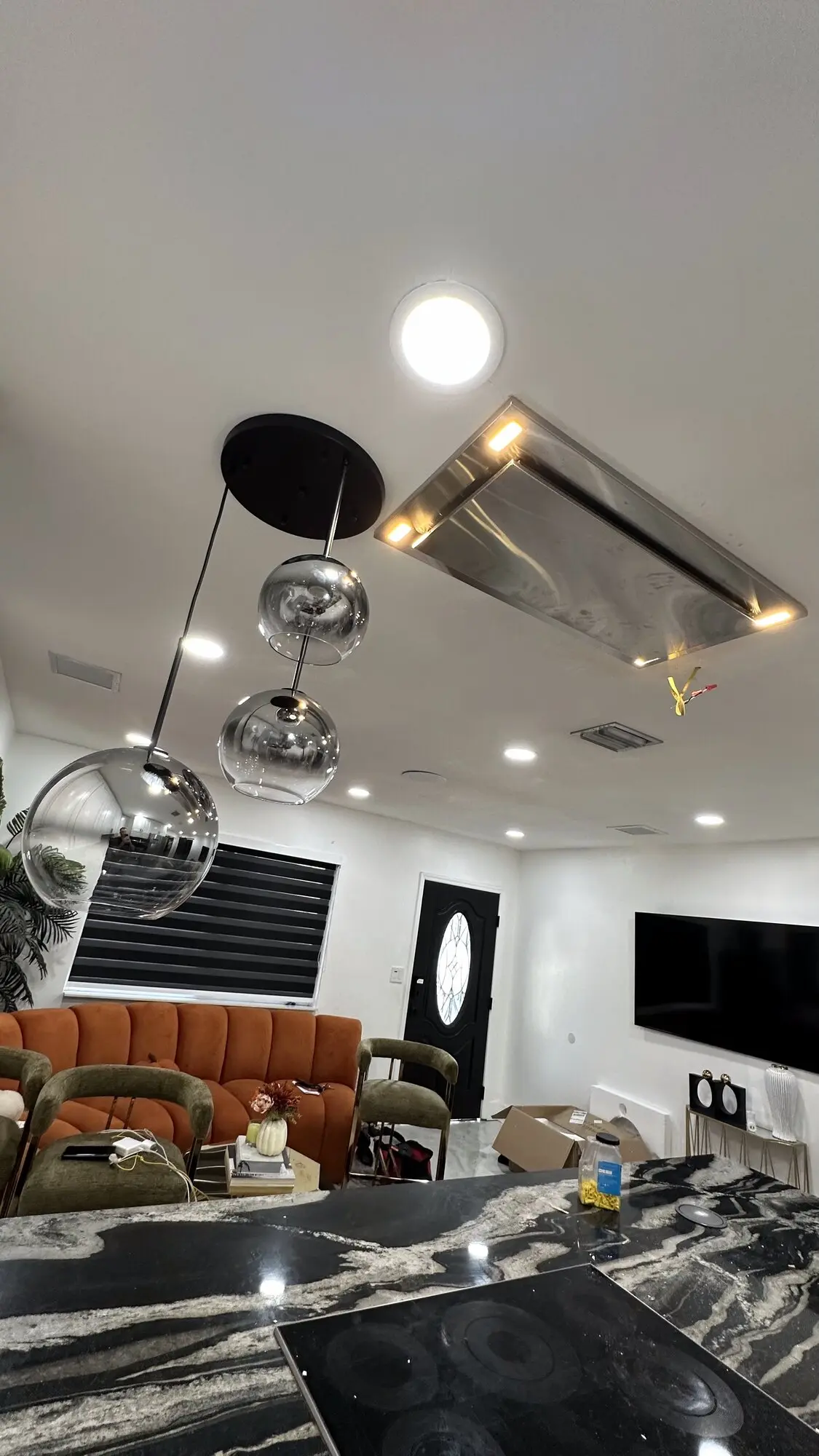 Finished kitchen with an installed range hood and decorative pendant lighting