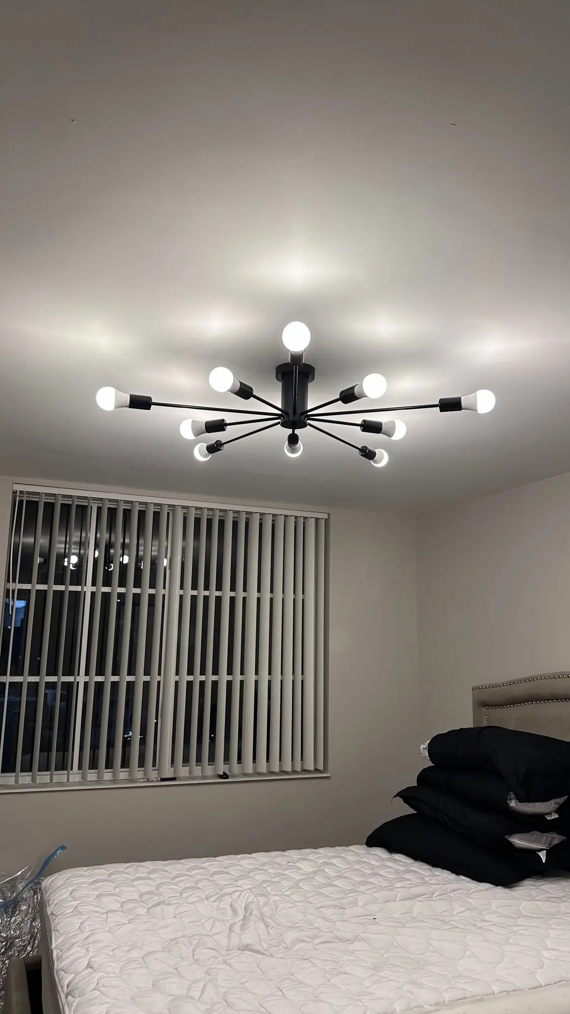 Sputnik-style chandelier installed above a bedroom