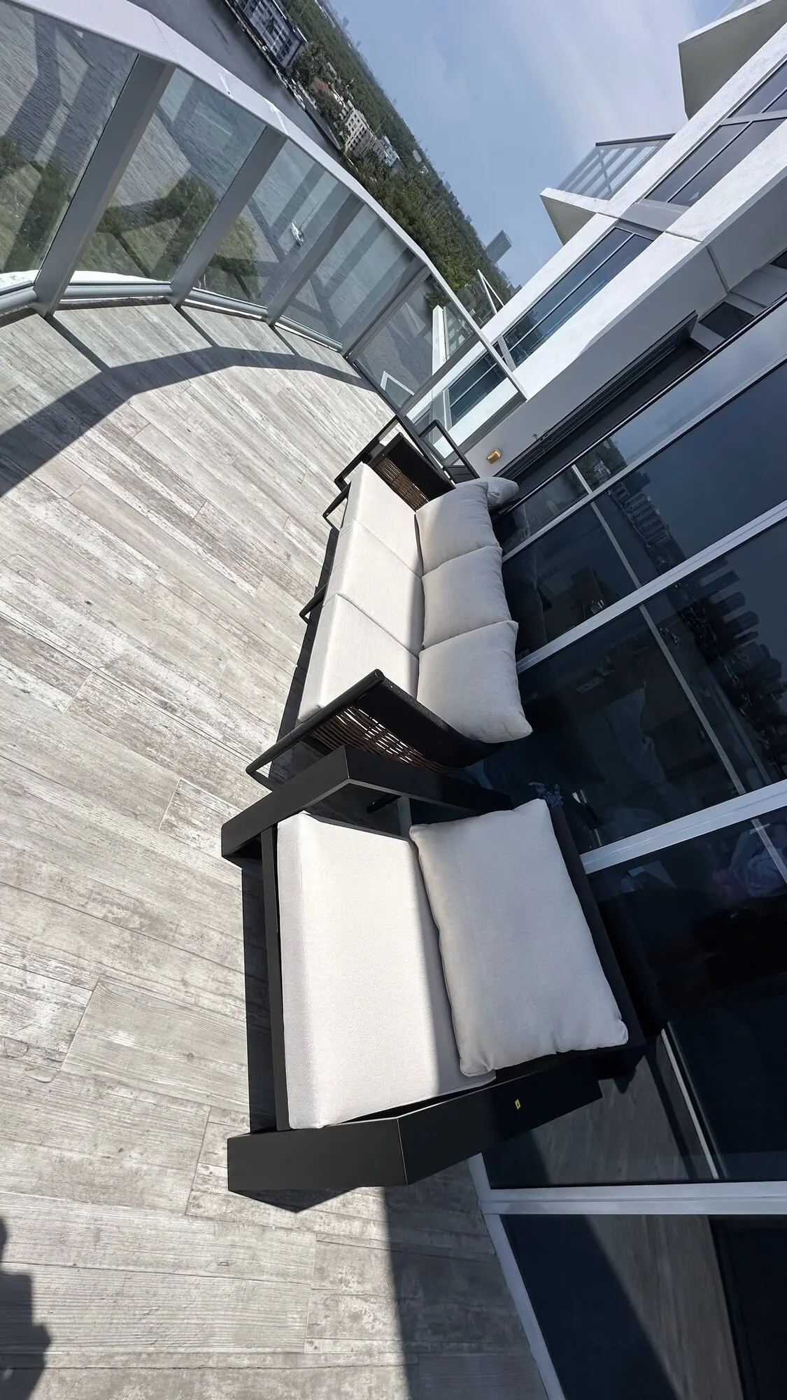 Outdoor bench seating installed on a terrace beside a glass building