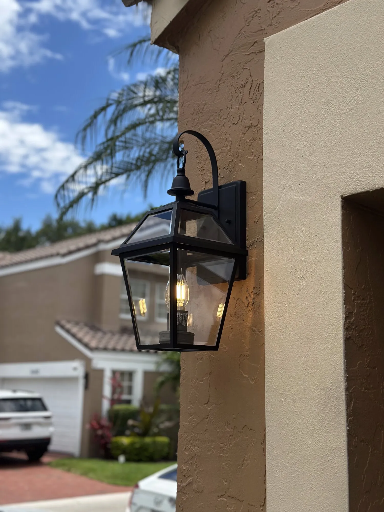 Outdoor lantern wall light securely mounted on a South Florida exterior wall
