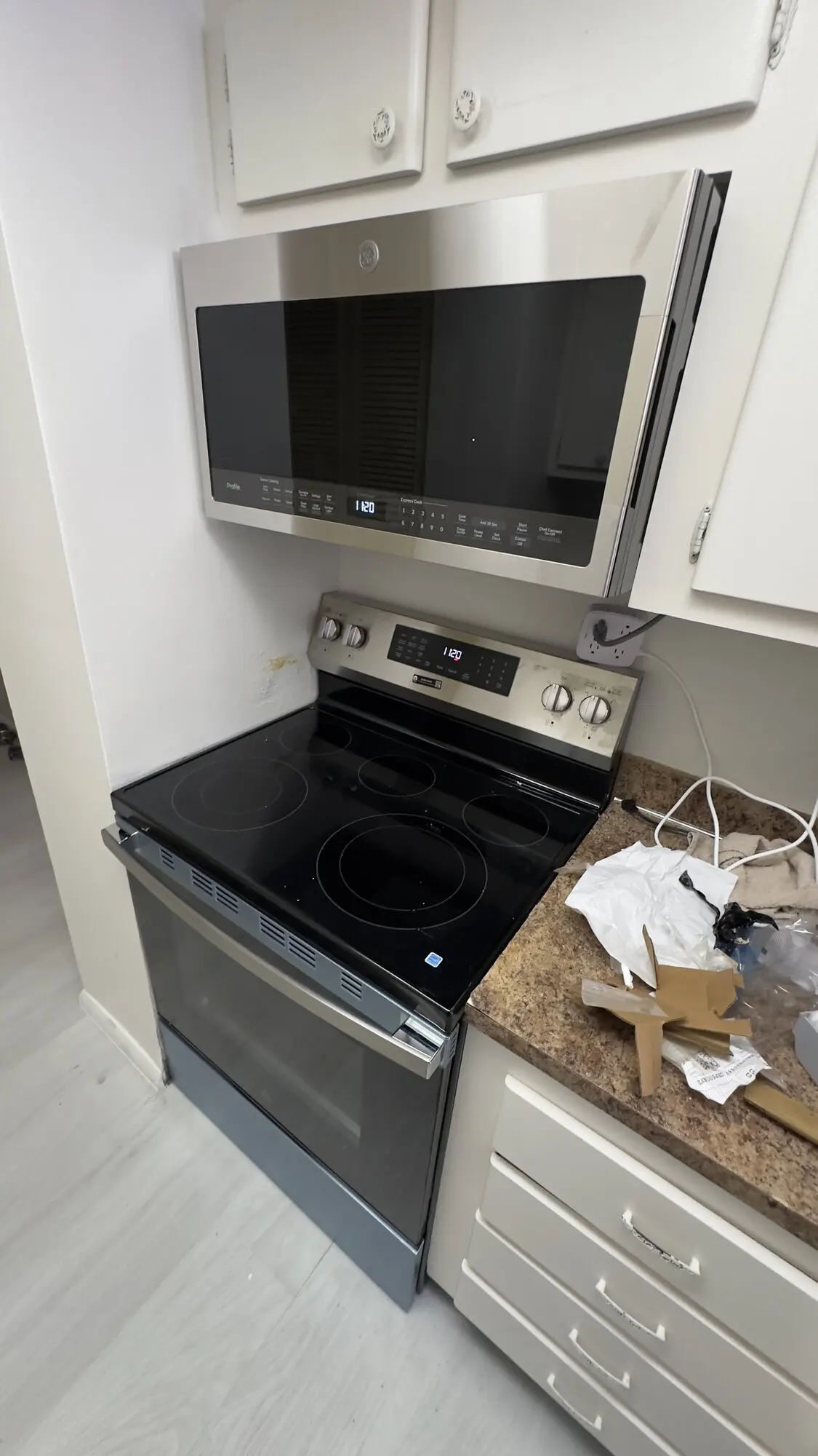 New range and over-the-range microwave installed in a white kitchen