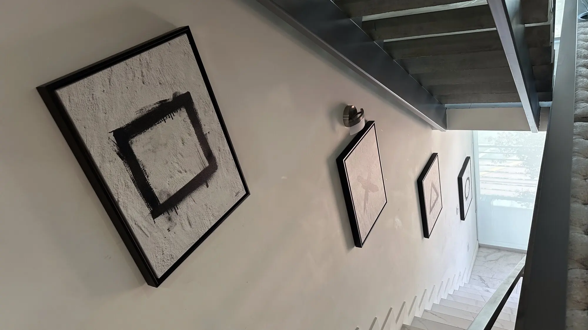 Gallery wall of framed art climbing alongside a staircase