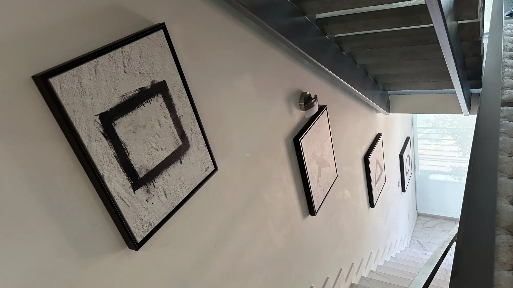 Gallery wall of framed art climbing alongside a staircase