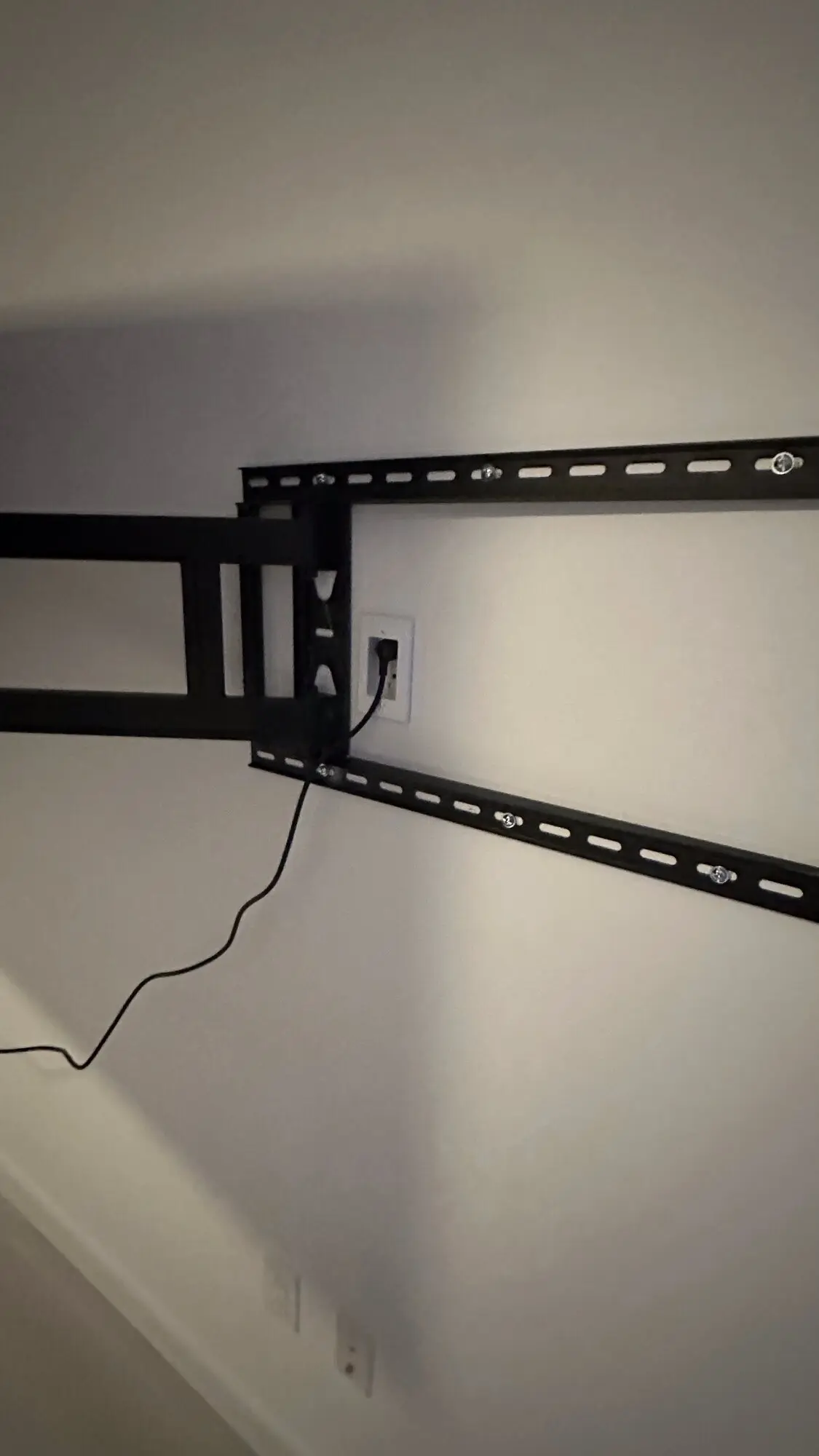 Full-motion TV wall mount bracket installed and leveled on a bare wall