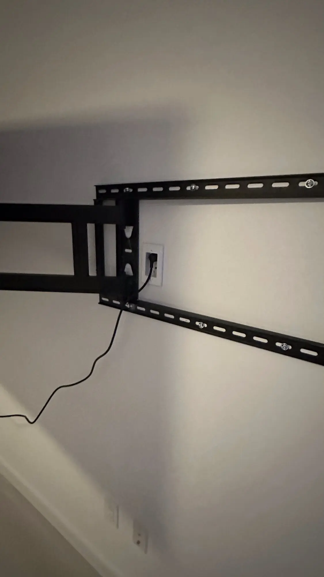 Full-motion TV wall mount bracket installed and leveled on a bare wall