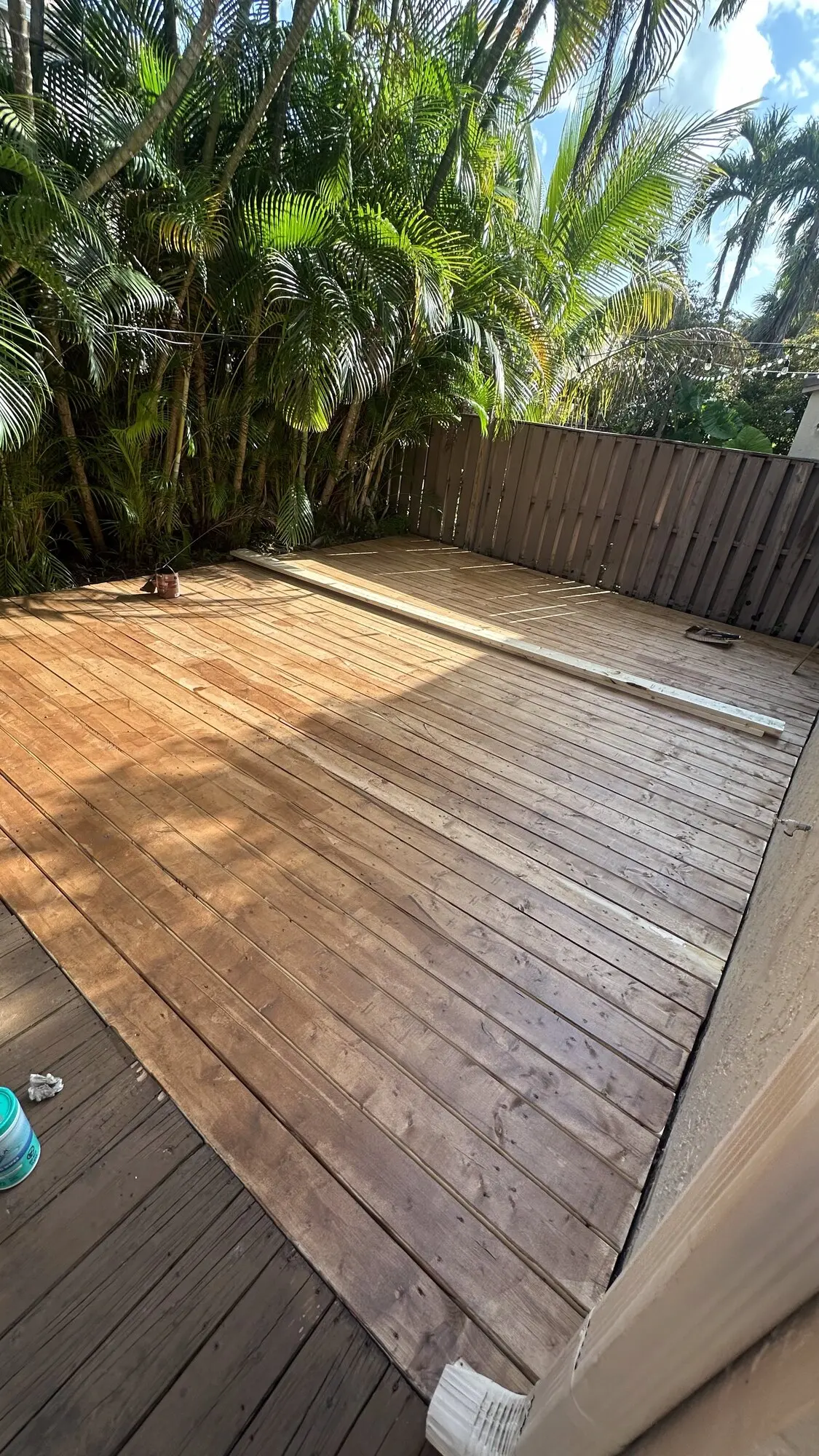 Newly built wooden deck in a tropical South Florida backyard with palm trees